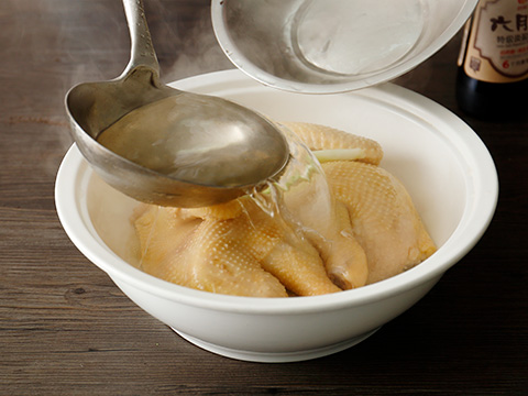 鸡放入炖锅,再注入冷水 500g,放在炉子上慢火炖至鸡肉酥软,捞出,淋上鸡汤。