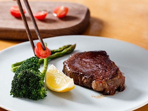 煎好的牛排装盘,用西红柿、西兰花、芦笋、柠檬点缀。